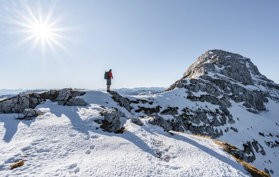 Climbers on the rocky summit ridge with first snow in autumn, hiking trail to Guffert, solar reflex, Brandenberg Alps, Tyrol, Austria
