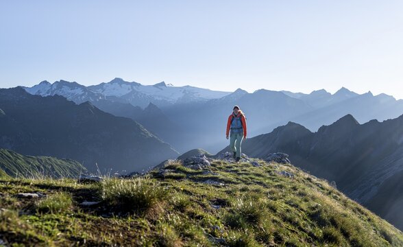 Hiker enjoying the mountain panorama in the morning, Venediger group, behind Dreiherrenkopf, Simonysitze and Gro&szlig;er Geiger, Hohen Tauern, Austria