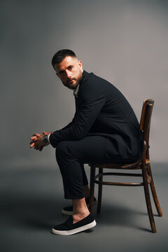 Confident handsome man sitting on wooden chair