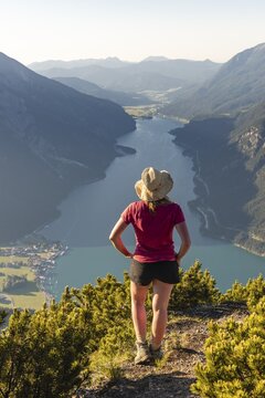 Young hiker, woman looking into the distance, view from B&auml;renkopf mountain to Lake Achen, left Seebergspitze and Seekarspitze, right Rofan Mountains, Tyrol, Austria