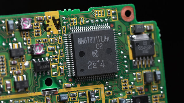 classic green motherboard with chipsets, memory modules, transistors and contacts