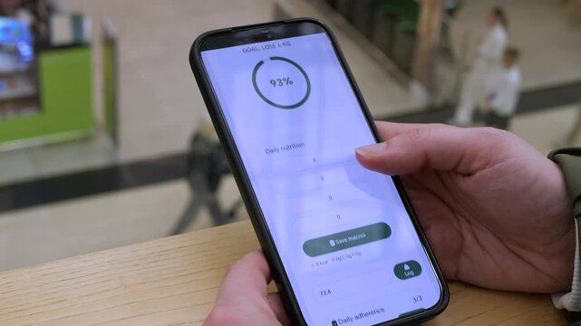Close-up of a hand scrolling through a daily macro tracker. Checking adherence to breakfast, lunch, and dinner logs. Ideal for fitness apps, dietitian tools, and personalized wellness technology.