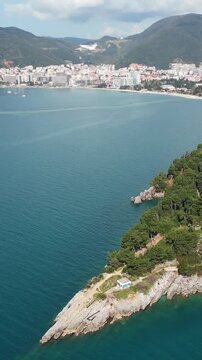 Aerial view of cape boreti revealing the city of budva in montenegro. Stunning turquoise waters of the adriatic sea meeting the rocky coast