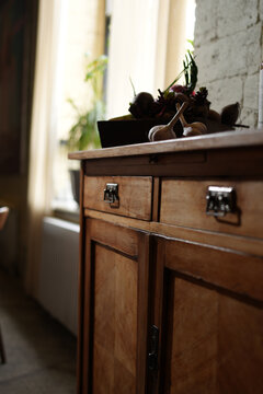 Vintage wooden cabinet with fresh organic vegetables and garlic in a cozy rustic kitchen interior