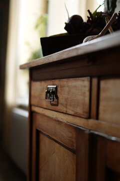 Vintage wooden cabinet with fresh organic vegetables and garlic in a cozy rustic kitchen interior