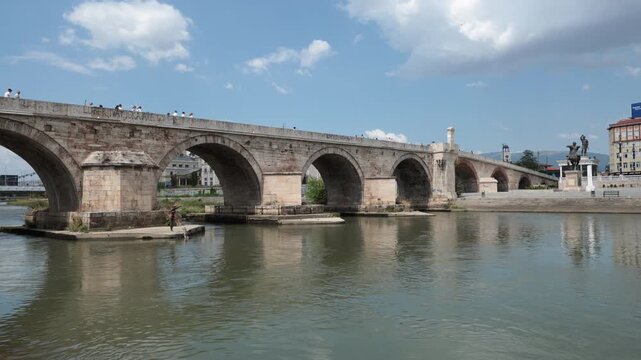 Skopje, North Macedonia - August 6, 2025: Stone bridge over Vardar river, Skopje. Urban construction and city infrastructure in Central Municipality in capital of Macedonia.