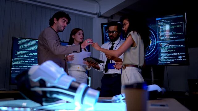 Creative business and engineering team reviewing product prototype and digital design documents in high tech innovation laboratory workspace