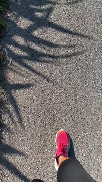 donna che cammina sulla strada con scarpe rosa