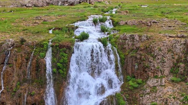 Close up aerial view of Konarli Waterfall cascading down rocky cliffs in Erzincan Turkey