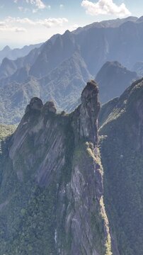 High-altitude aerial view of Dedo de Deus surrounded by rugged mountain ridges and tropical forest.