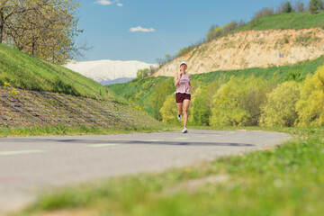 Naklejka premium Young woman jogging on a path