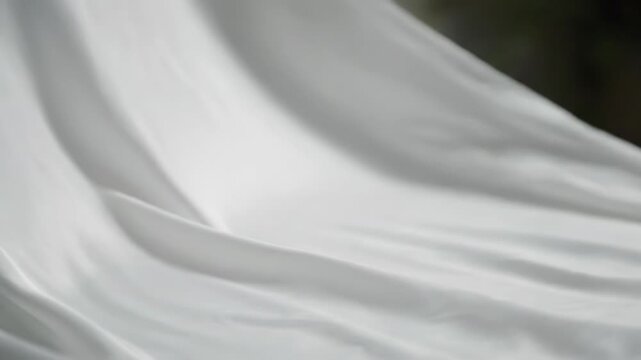 Cinematic slow motion of luxurious white silk fabric gracefully flowing and undulating in a gentle breeze, creating a soft, elegant, and abstract texture sophisticated, serene, calming