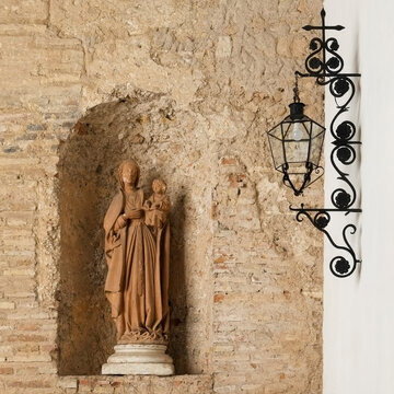Religious Statue and Wall Lantern in Seville