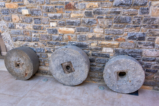 Ancient stone millstones and clay amphoras in heritage museum