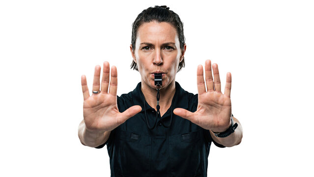 White male referee blowing whistle and showing stop sign with both hands. Middle aged adult man in official uniform looking at camera on transparent background. Concept of sports rule, and authority.