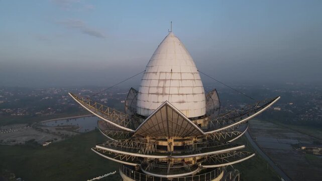 Aerial view of Menara Pandang Teratai showing the lotus-shaped dome and petal structures overlooking the city skyline in Kecamatan Purwokerto Timur, Jawa Tengah, Indonesia.