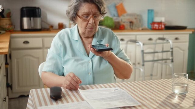 Senior woman pays household bills by scanning a QR code with her smartphone, showing digital payments, financial independence and everyday technology.