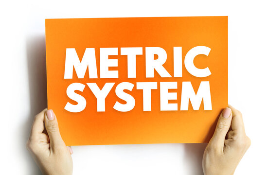METRIC SYSTEM text on card held by hands. Concept of scientific measurement and international standards. Idea representing units of length, mass, and volume consistency