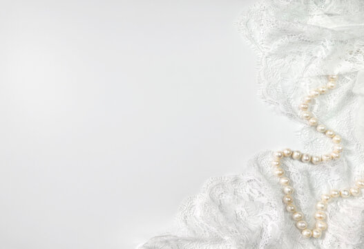 White lace fabric and pearl necklace elegant background