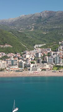Aerial view of a white sailing yacht anchored in Becici Bay, Montenegro