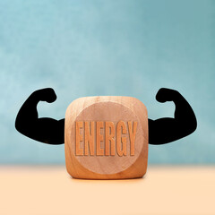 Wood block with energy label and flexing arms shows strength and motivation for wellness and fitness