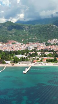 Stunning aerial perspective of the beautiful budva cityscape in montenegro, showcasing the turquoise adriatic sea, sandy beaches, and lush green mountains
