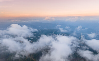 Fototapeta premium Wind turbines amid clouds in Da lat, Vietnam at sunset