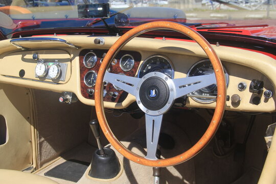 BINIC, FRANCE - JUIN 7, 2026 : Plan rapproch&eacute; sur le tableau de bord d'une voiture de sport classique britannique Triumph TR3, avec volant de collection en bois &agrave; trois branches.