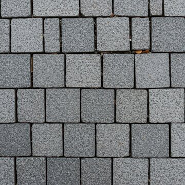 Rough gray granite sett pavement texture creating a durable, historic, and classic outdoor paving surface. Ancient stone surface suitable for abstract backdrops, neutral, sett, exterior