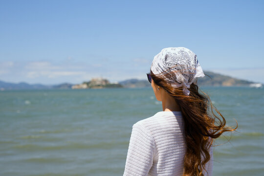 Young woman gazing across San Francisco Bay toward Alcatraz Island