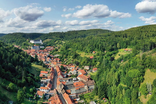 Malerische Luftaufnahme von Stolberg im Harz mit historischen Fachwerkh&auml;usern, eingebettet in die gr&uuml;ne Berglandschaft mit Blick auf das Schloss. Perfekt f&uuml;r Tourismus und Reisen.