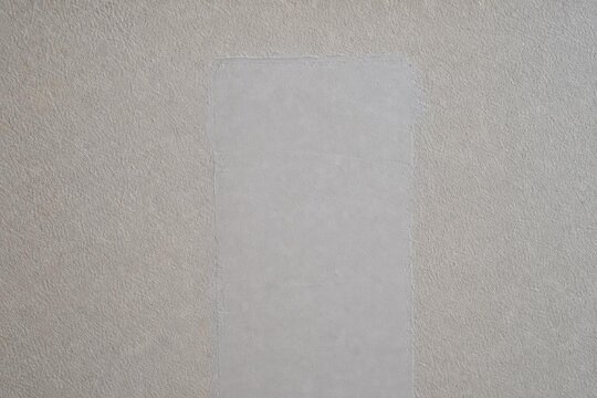 Close-up of a repaired wall showing texture difference between old and new patch.