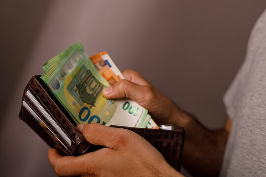 Hands holding euro cash money in a wallet for financial transactions.