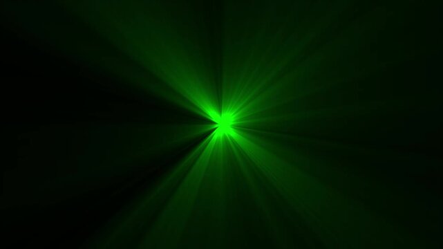 Green lens flare light effect with radiant beams on black background