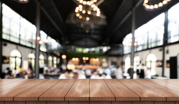 Empty wooden table top with lights bokeh on blur restaurant background.