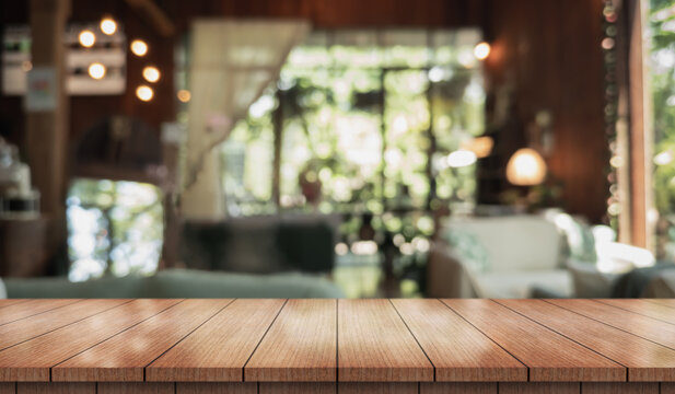 Empty wooden table top with lights bokeh on blur restaurant background.