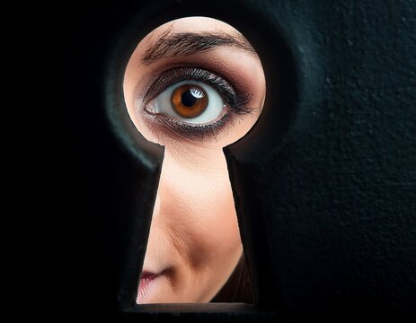 eyes peeking through a keyhole representing spying and lack of trust