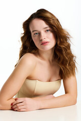 Fototapeta premium Young beautiful woman showcases fashion and allure in a striking studio setting with natural beauty