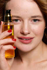 Fototapeta premium Young beautiful woman showcases skincare product in alluring studio setting