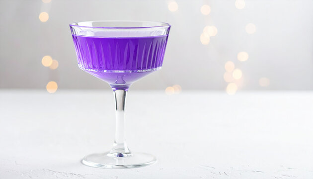 Purple violet drink in vintage glassware, sparkling wine glass style, soft bokeh lights, tasty beverage. Delicious and airy. Close-up.