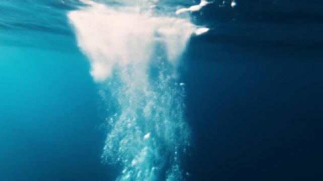 Bubbles rising from depth in clear blue ocean water surface view