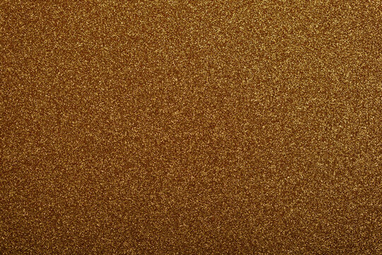 A seamless background texture filled with sparkling golden glitter particles, offering a luxurious f