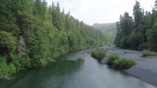 Rising view over a crystal clear river in the Pacific Northwest exposing more gravel bar as the view rises. 