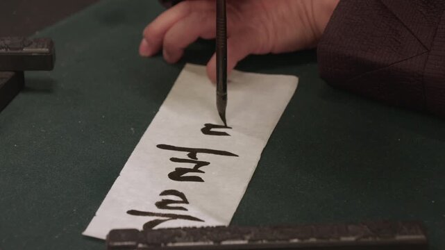 A calligrapher writing with brush and ink. man hand writing Mongolian calligraphy with ink