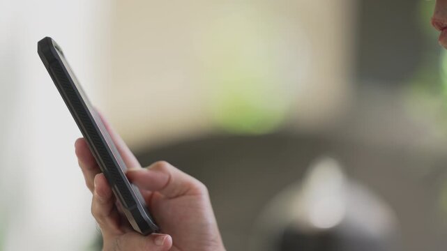 Minimalist close-up slow zoom on hand pressing smartphone screen with clean green nature background, ideal for mobile application user interface demo or digital technology layout.