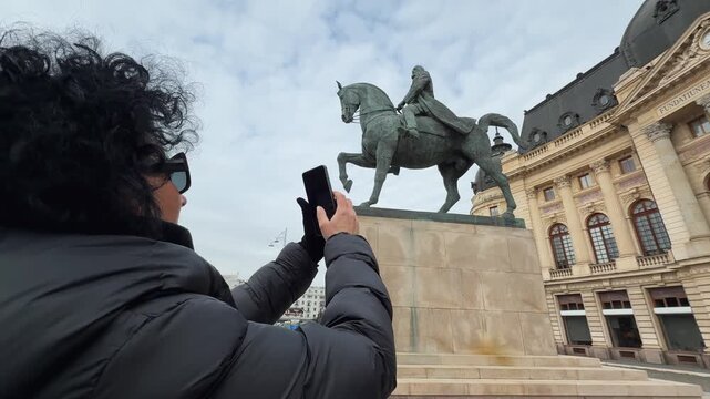 Woman Capturing Historic Equestrian Statue of Carol I in Bucharest