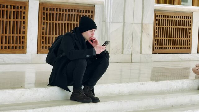 Tourist Uses Phone at Palace of the Parliament, Bucharest
