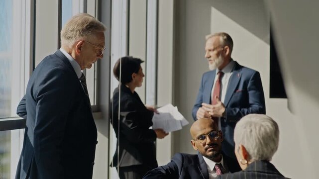 Handheld shot of diverse executives, including Caucasian and Indian colleagues, discussing corporate strategy during oil industry meeting. Video is ideal for business presentations