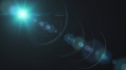 Fototapeta premium Blue lens flare with circular light rings on dark.
