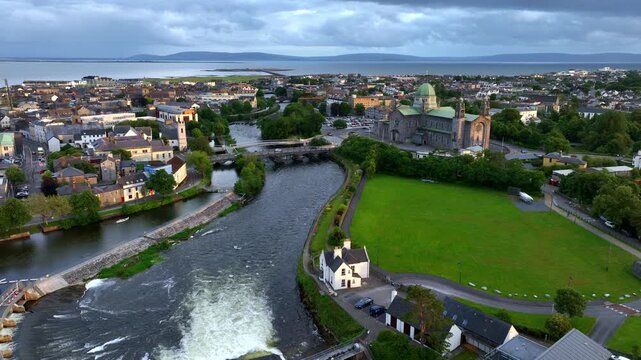 Galway town and Corrib river at sunset, drone shot of famous Galway cathedral and Salmon Weir bridge and Dam, aerial view of Galway, travel and tourism in Ireland, Irish city on the Atlantic coast